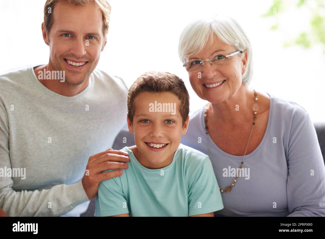 We couldnt be any prouder. Portrait of a young boy sitting with his father and grandmother. Stock Photo
