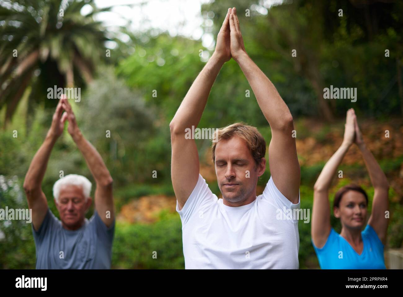 Focus and breathe. a young man leading a breathing exercise in an outdoor yoga class. Stock Photo