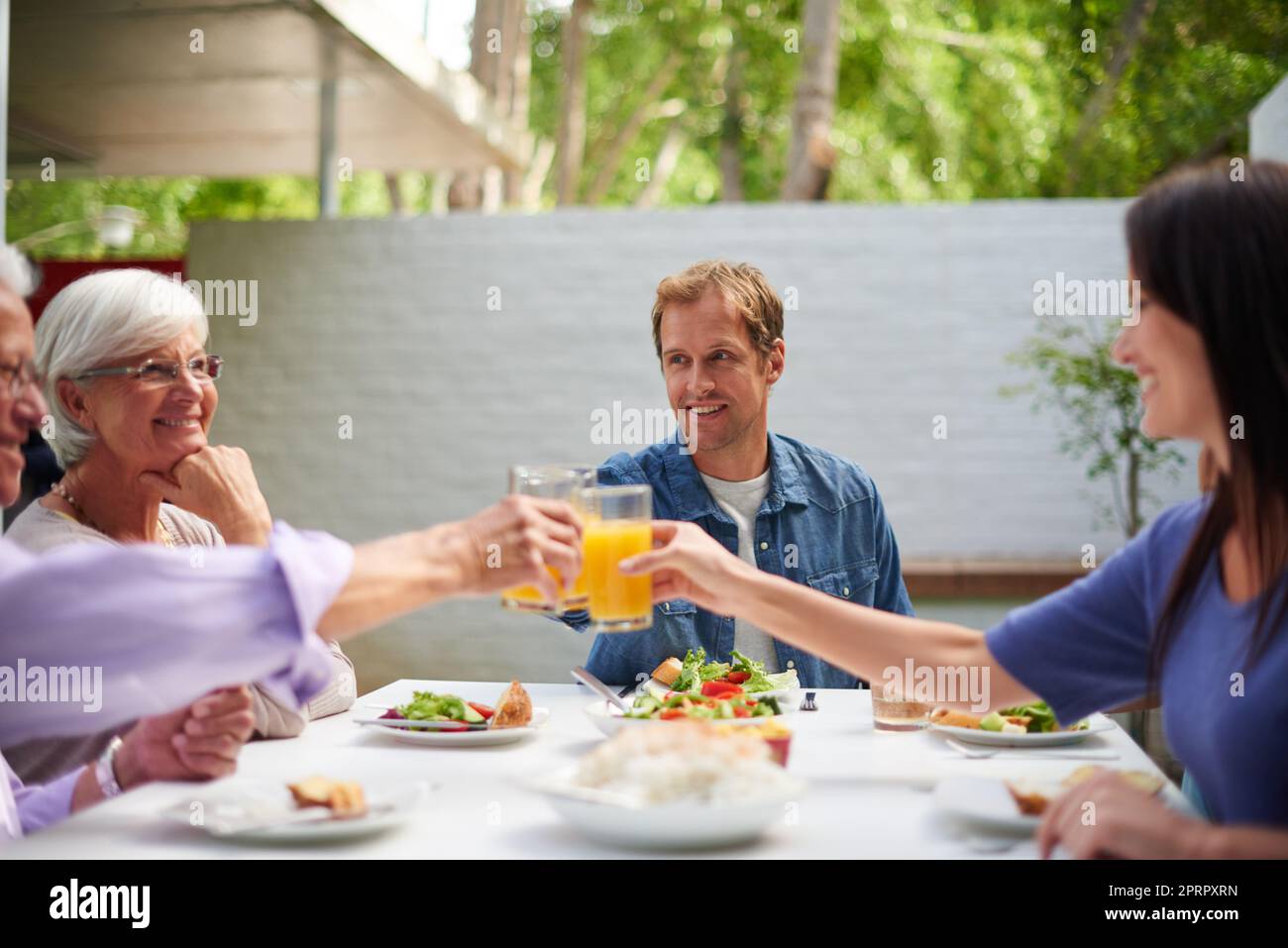 Heres to family. father and mother toasting their adult children while having lunch outside. Stock Photo