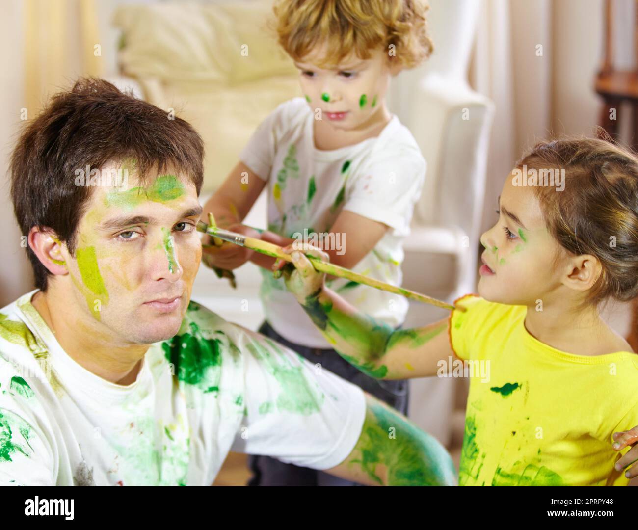 This is what happens when Moms away for the weekend. a dad being painted by his children. Stock Photo