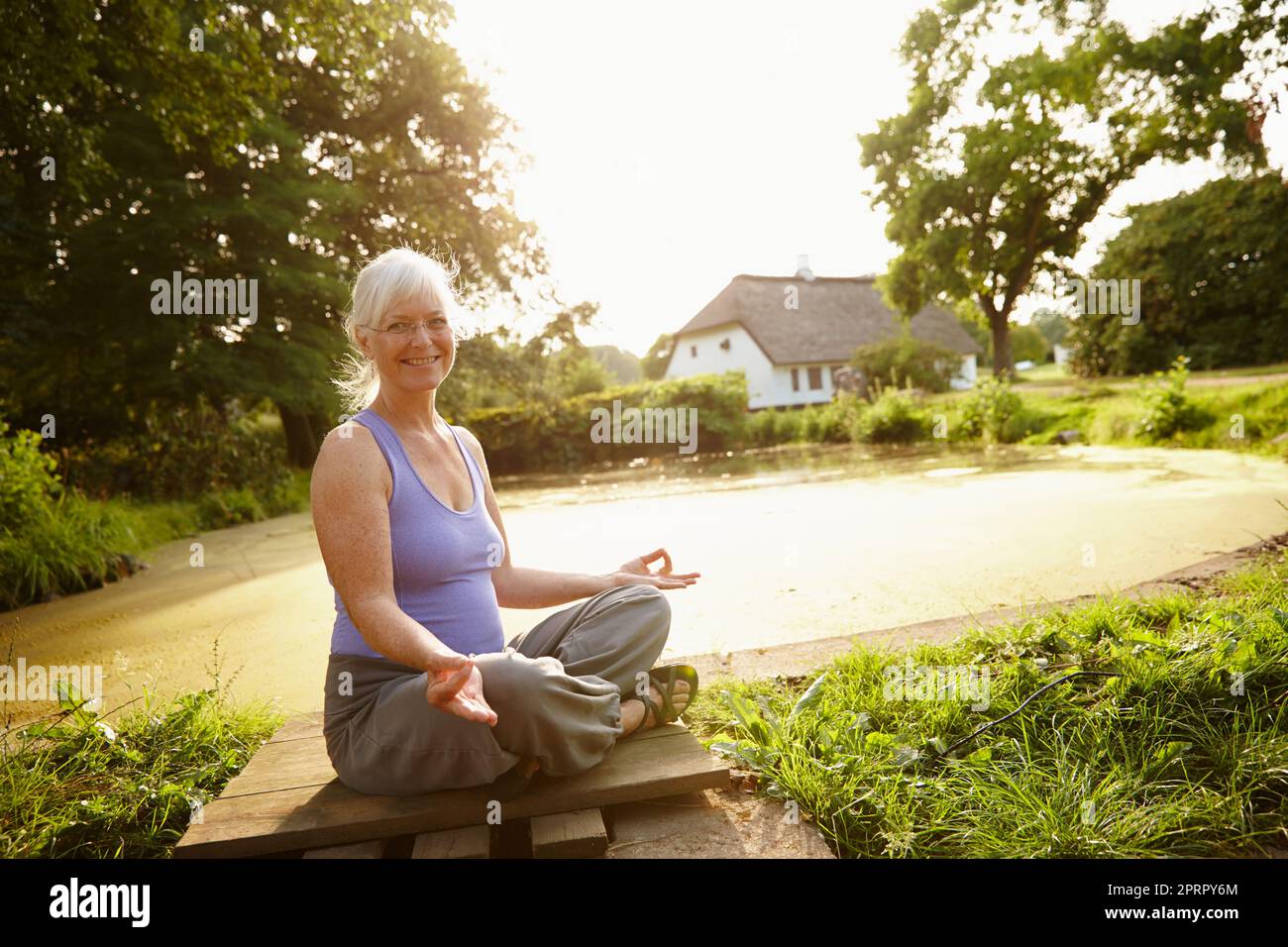 Bringing body, mind and spirit in harmony. Portrait of an attractive mature woman sitting in the lotus position in a garden setting. Stock Photo