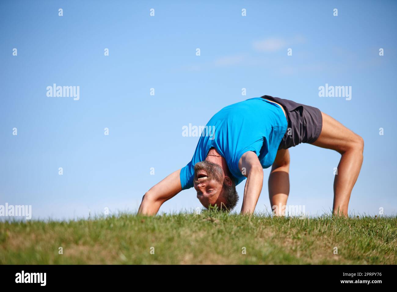 Perfecting a difficult posture. Full length shot of a handsome mature man doing yoga outdoors. Stock Photo