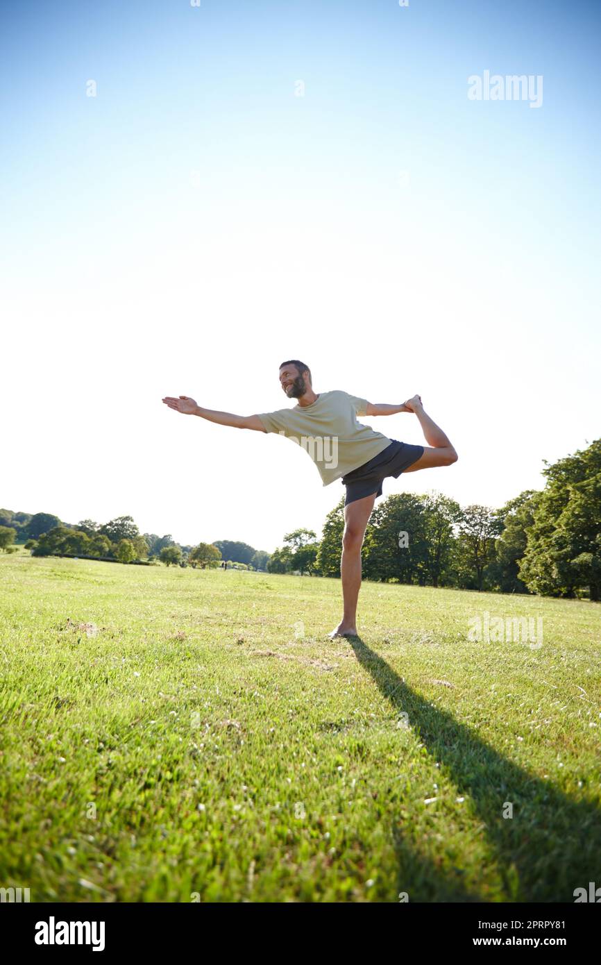 Leading a balanced lifestyle. Full length shot of a handsome mature man doing yoga outdoors. Stock Photo
