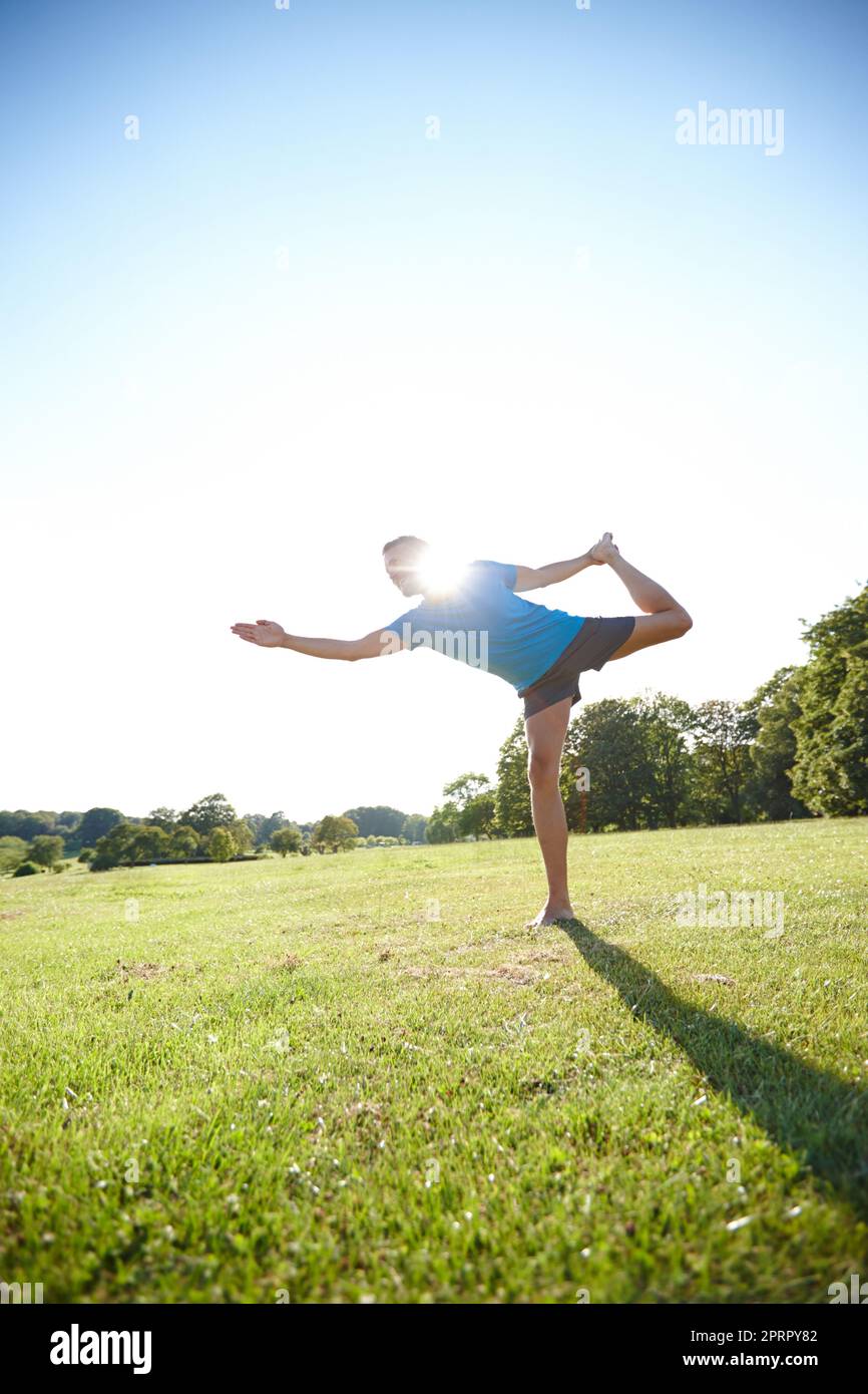 Yoga is the poetry of movement. Full length shot of a handsome mature man doing yoga outdoors. Stock Photo