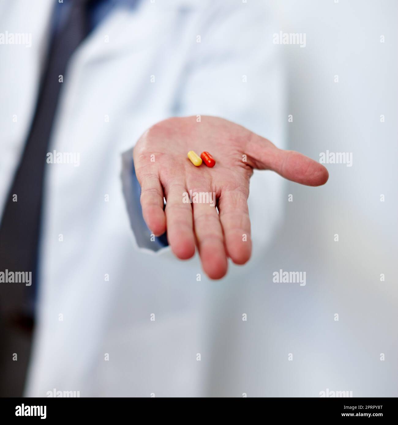 Dont depend on it. a doctor holding two capsules in his hand. Stock Photo