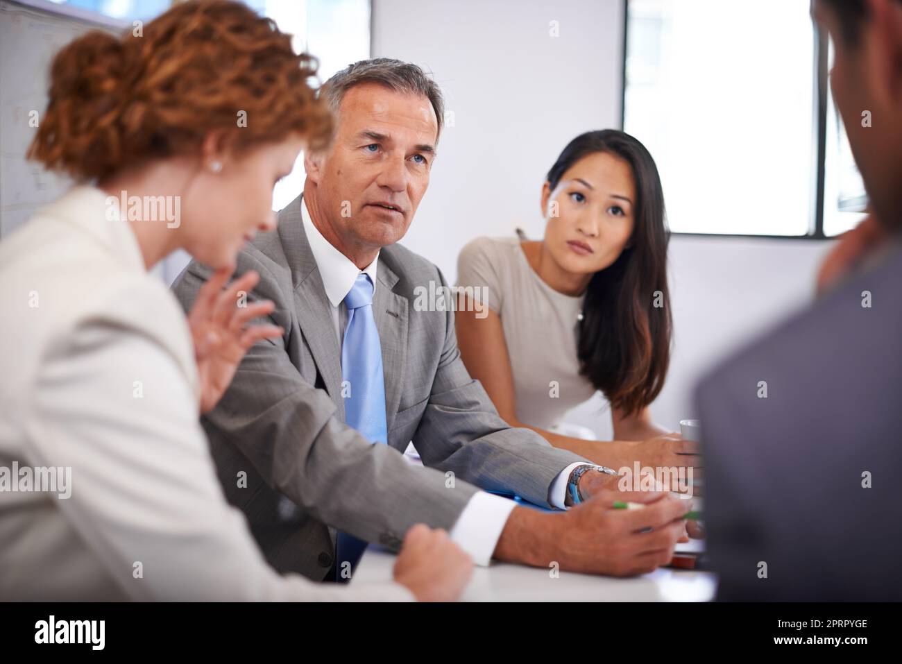 The deadline is looming. a group of businesspeople in a meeting. Stock Photo