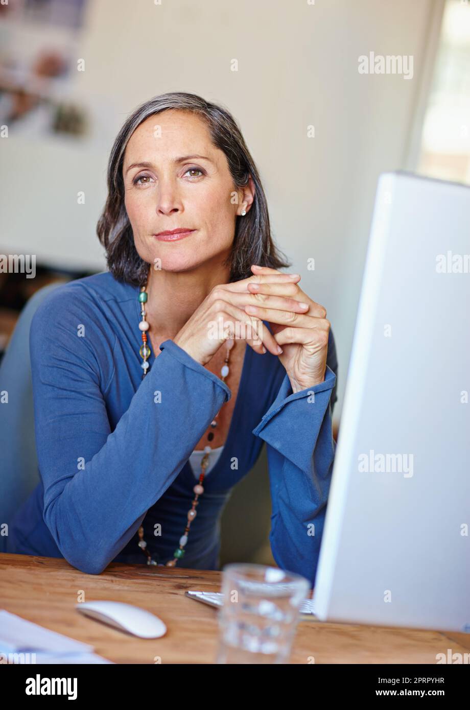 Shes good at what she does. Portrait of a mature female design professional sitting at her office desk. Stock Photo