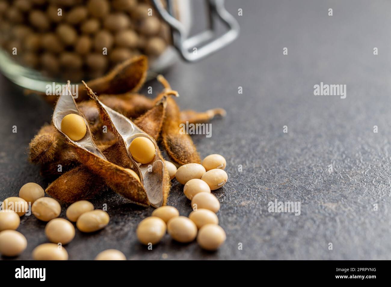 Soy beans. Dried soybean pod on black table. Stock Photo