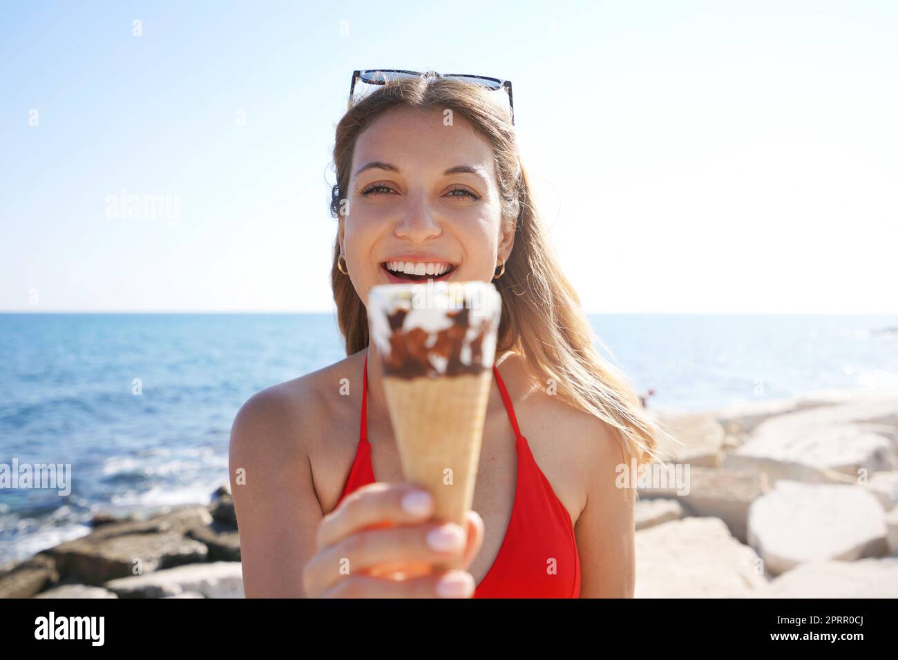 Closeup of beautiful bikini woman holding ice cream cone italian