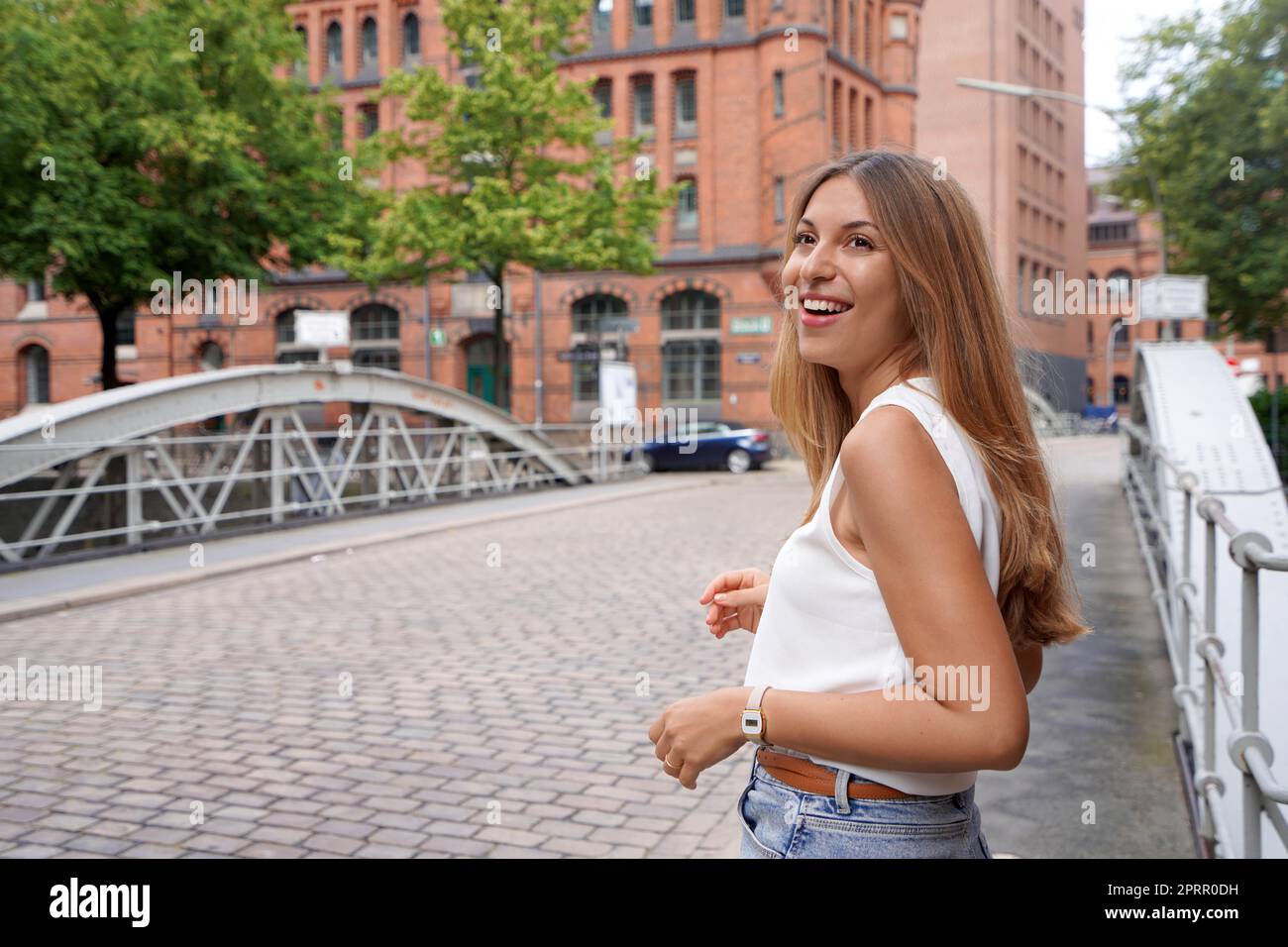 Attractive positive woman turns around and looking to the side in a Northern European city street Stock Photo