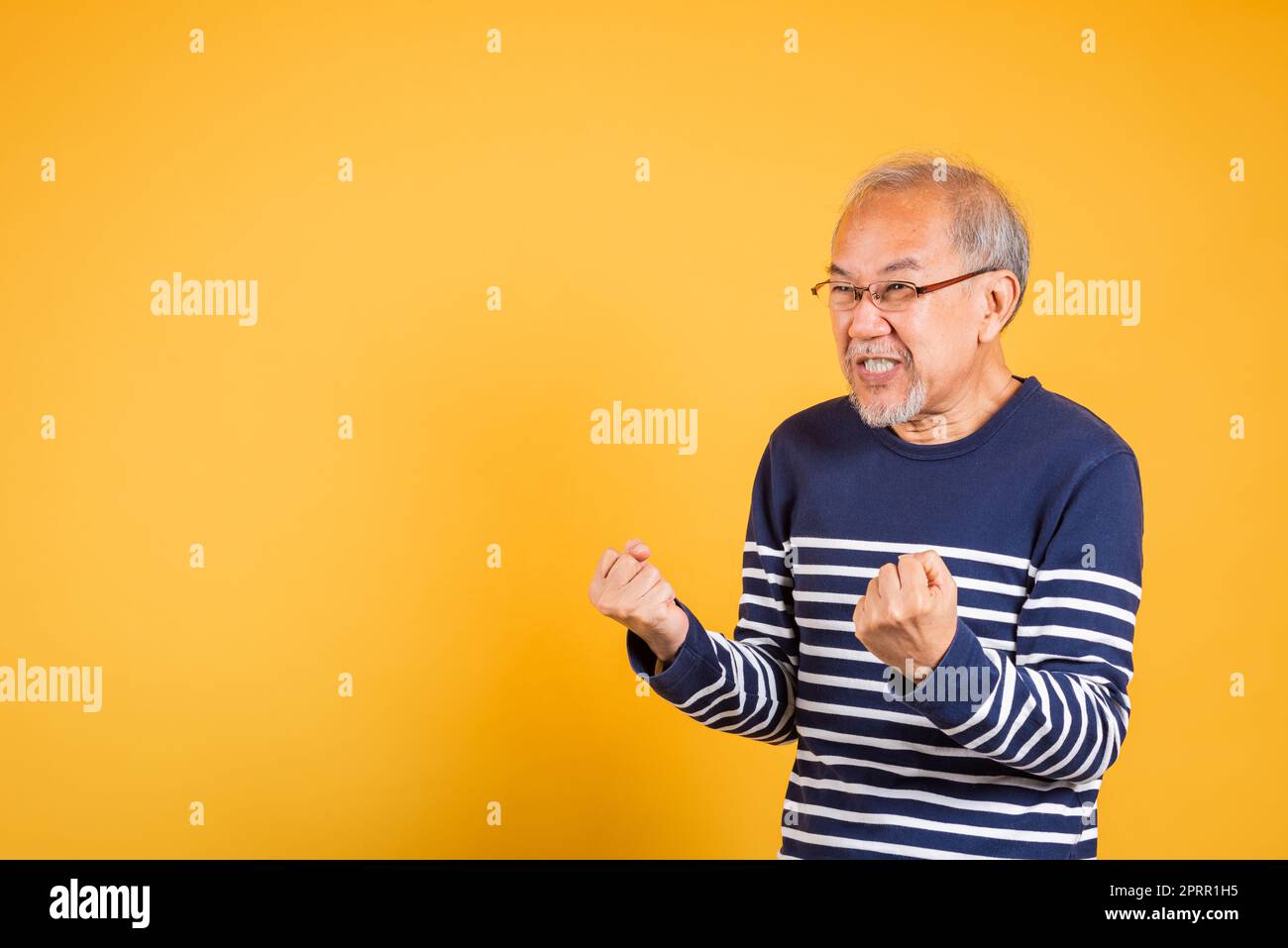 Happy Asian elder man with glasses excited say yes gesture like winner Stock Photo