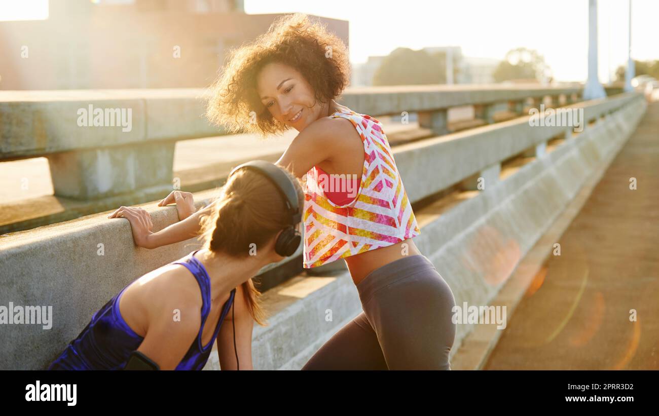 Im ready when you are. two female joggers preparing for a run in the city. Stock Photo