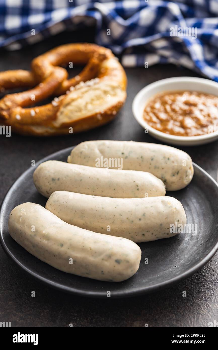 Traditional Bavarian white sausages on the plate and pretzes. Stock Photo