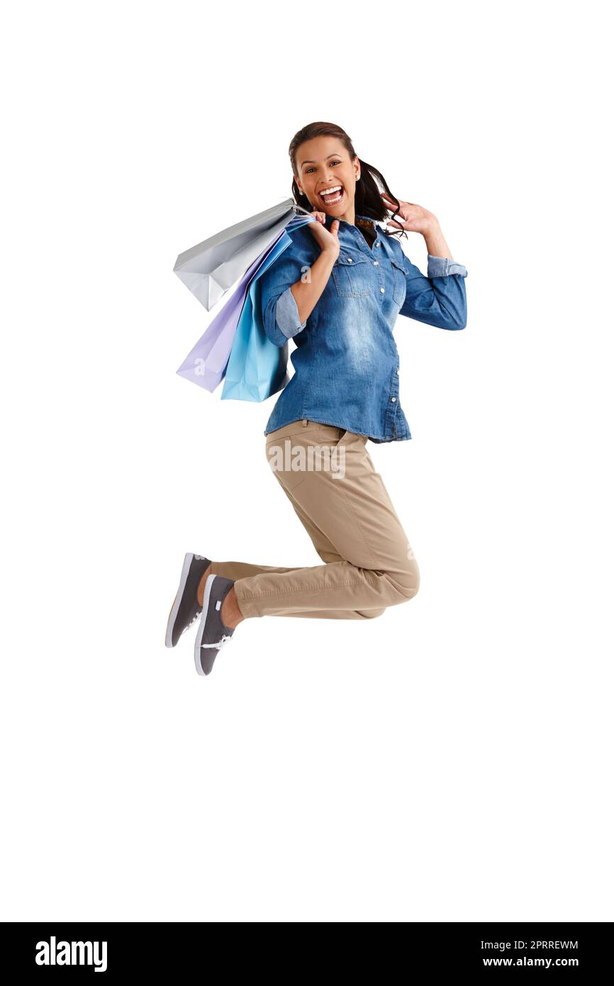 Put the spring back into in your step with a spending spree. Studio portrait of an attractive young woman carrying shopping bags isolated on white. Stock Photo