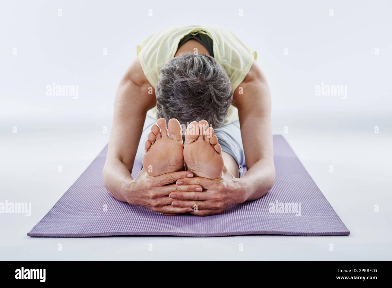 Pre-workout warmup. Full length shot of a woman stretching before yoga. Stock Photo