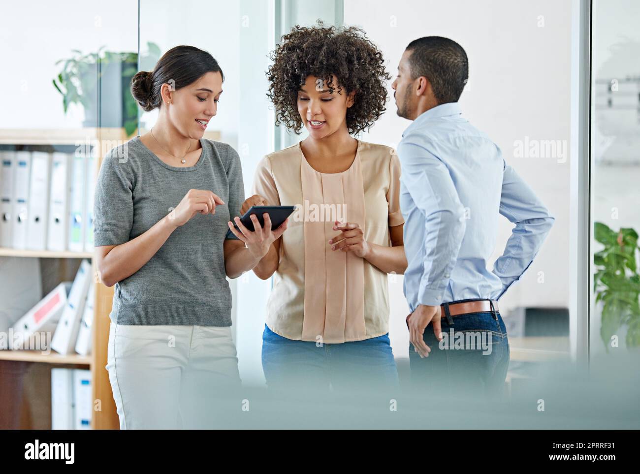 Teamwork makes the dream work. office colleagues having a discussion over a digital tablet. Stock Photo