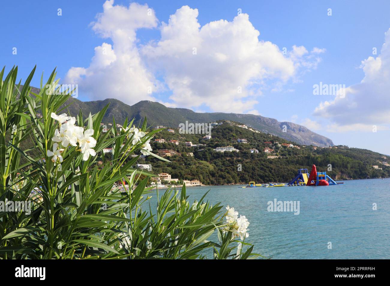 Beautiful beach in Ipsos on Corfu, tourists enjoying a nice summer day at the beach. Greece Stock Photo