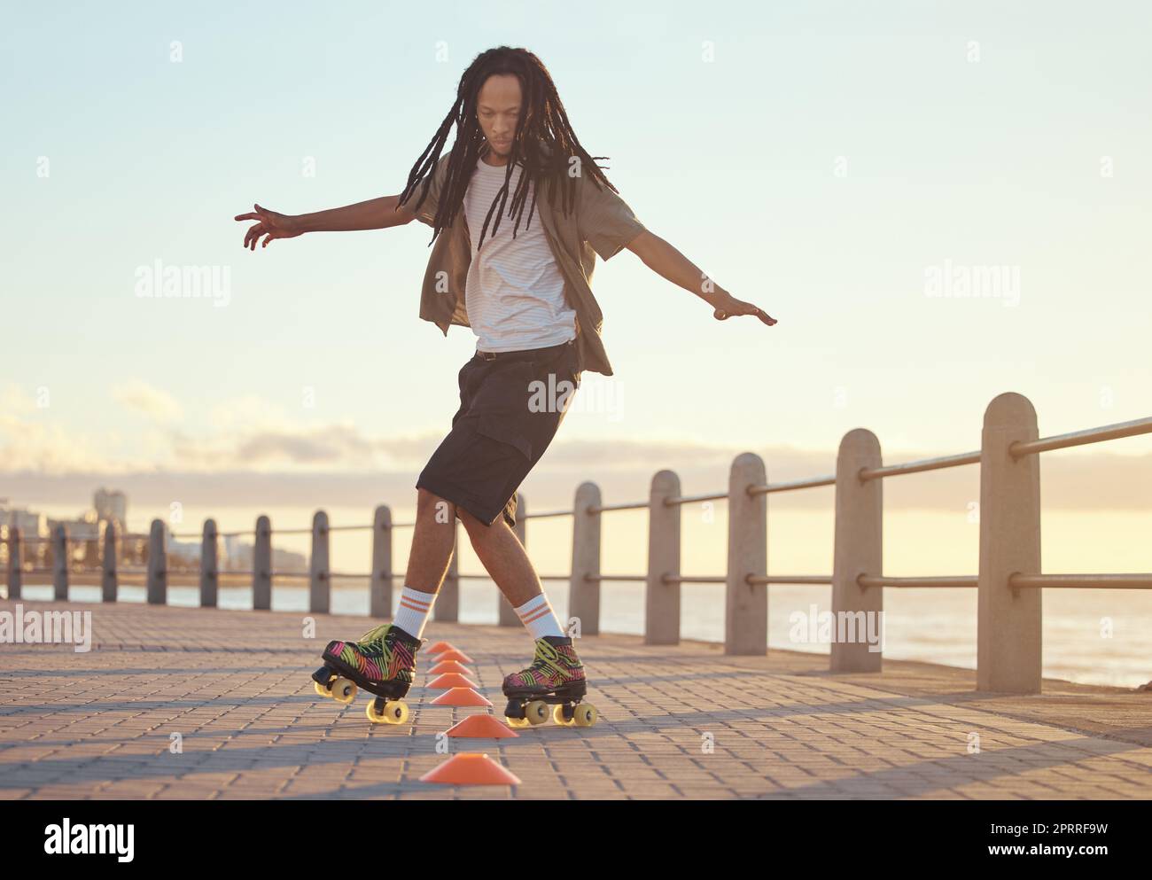Roller skates, beach and sport with a man riding around training cone for fun, fitness and