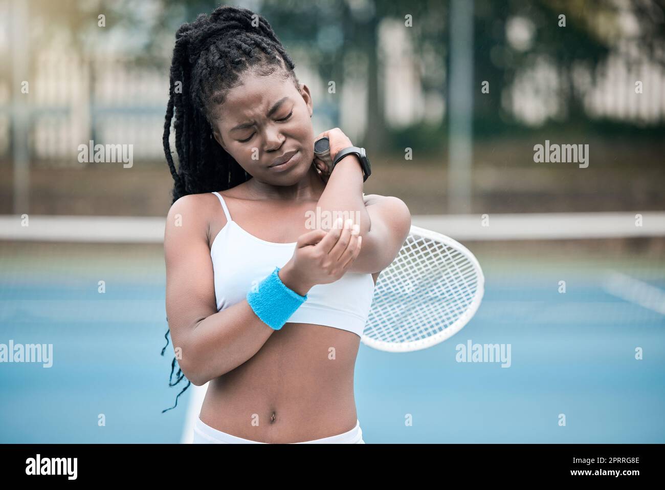 Injury, pain and elbow of tennis woman player with sad, hurt or crying emotion during match, game or training outdoor. Sports fitness athlete person with bone health stress or medical sport emergency Stock Photo