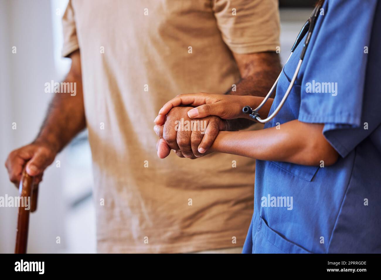 Support, trust and help from caregiver or nurse walking with senior man or patient in retirement home with healthcare insurance. Hands of female medical worker and alzheimers male with hospice care Stock Photo