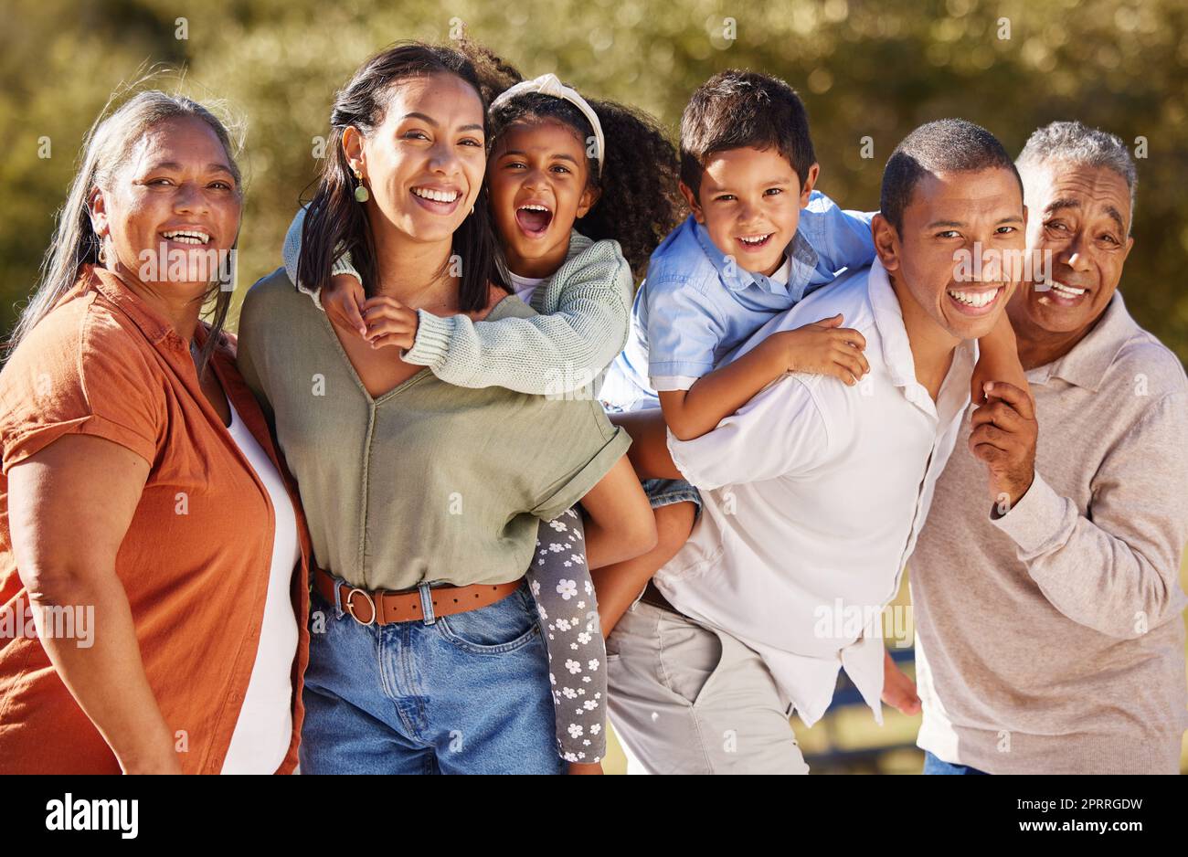 Big family, three generation and happy people sharing love, care and a special bond while at the park on a sunny day. Portrait of children, parents and grandparents out on a fun adventure in mexico Stock Photo