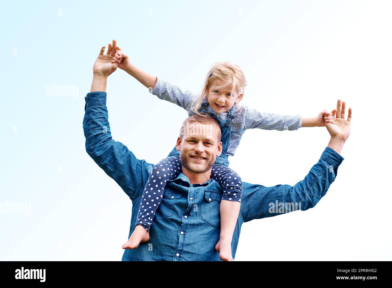 Riding high with Dad. Portrait of a happy dad carrying his young daughter on his shoulders. Stock Photo