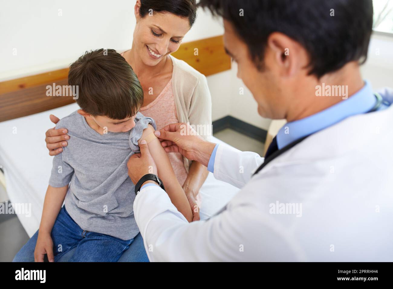 Heres a badge of bravery to show your friends. a mother watching her son being taken care of by his doctor. Stock Photo