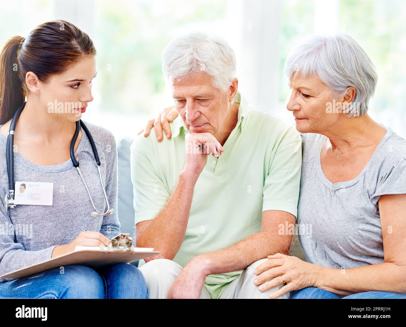 Youll need specialised care for this...A doctor explaining medical care to a senior patient and his spouse. Stock Photo