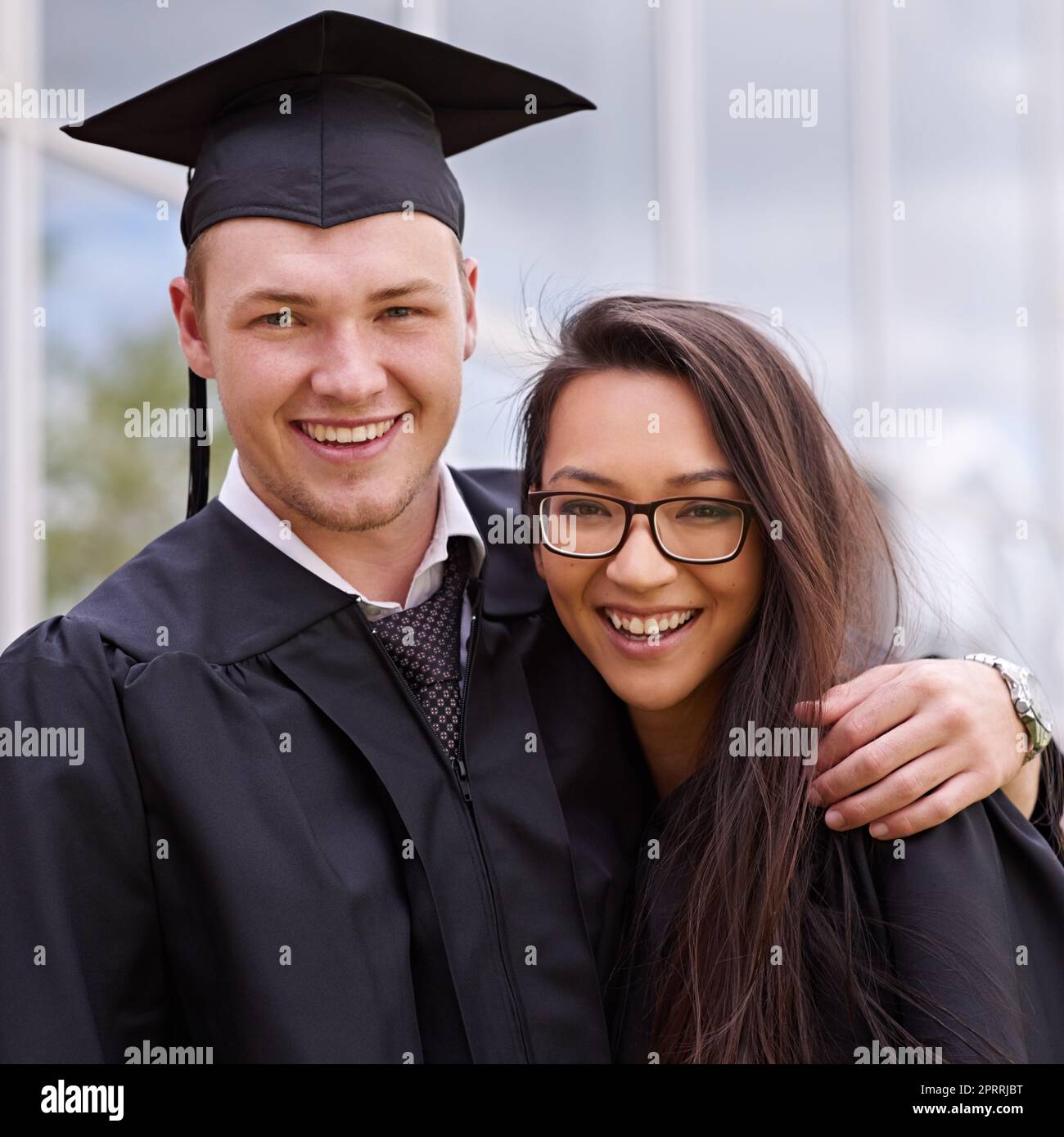 Diplomas achieved and friends made. Portrait of smiling friends on graduation day. Stock Photo