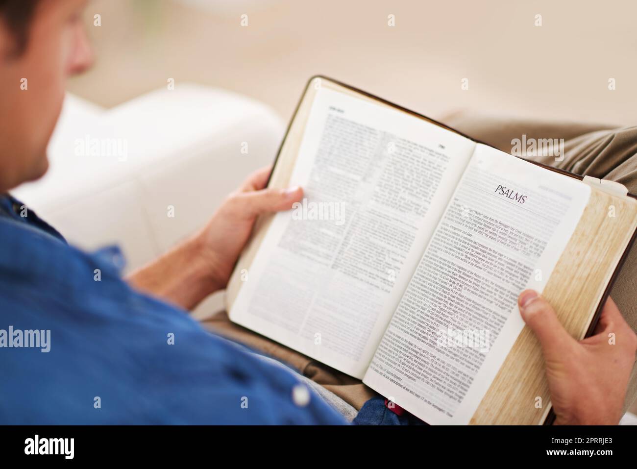 Reading through the psalms. a man reading the Bible at home. Stock Photo
