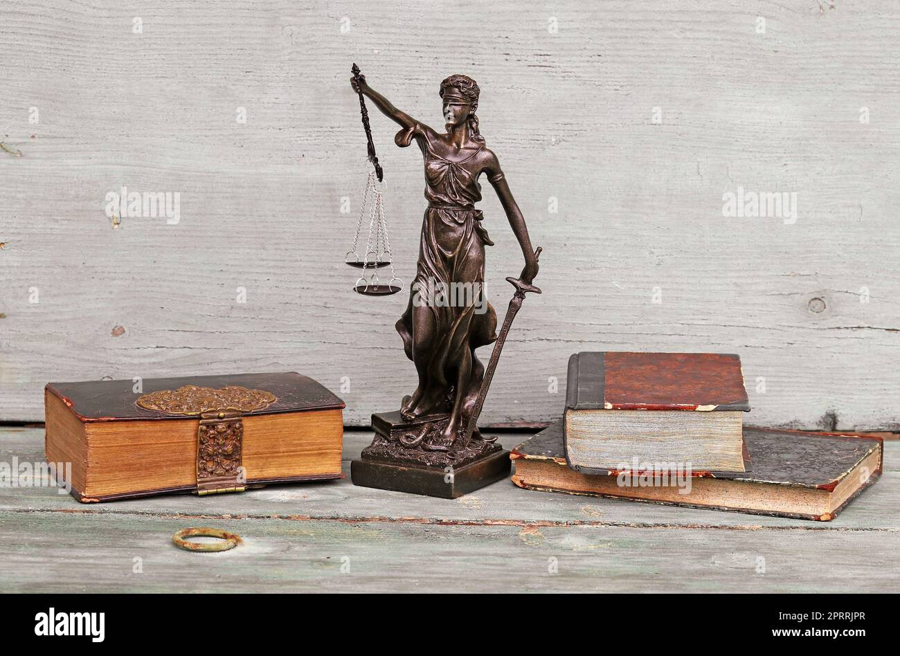 Justice figure and old books on a wooden background. Justice, scales and court Stock Photo