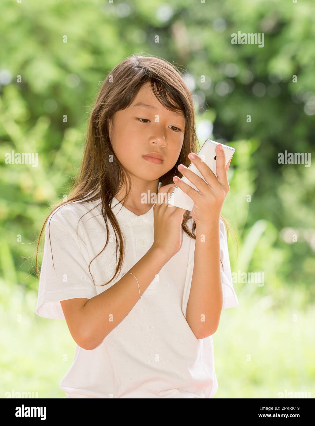 Asia girl use smart phone in garden Stock Photo