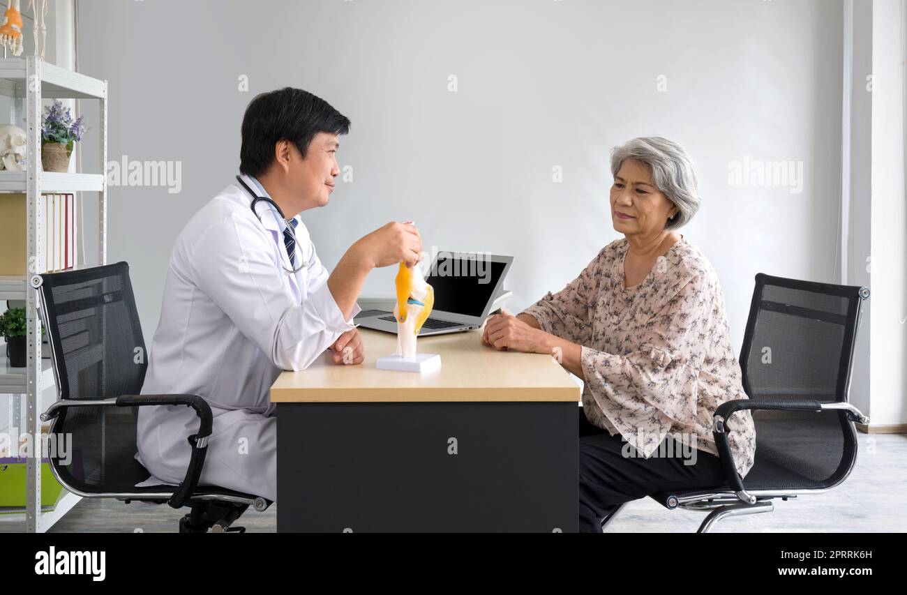 Asian Orthopedic Surgeon in white gown and stethoscope use human bone