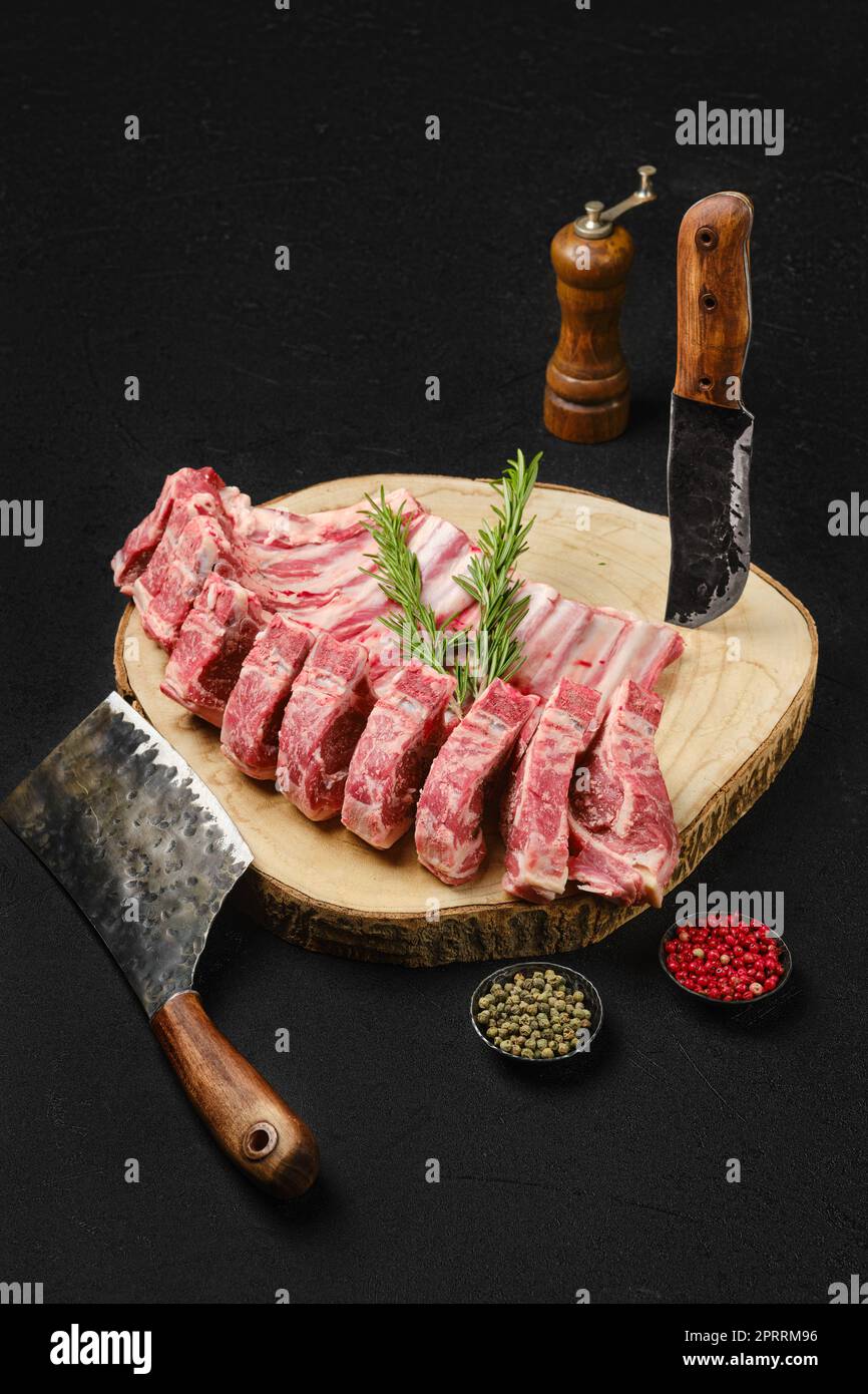 Raw lamb rib roast on wooden slab and butcher cleaver Stock Photo - Alamy