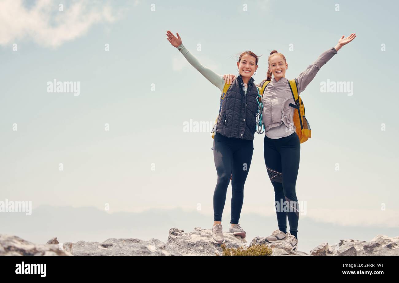 Travel, hiking and success with women on mountain cliff, trekking and adventure trip together. Freedom, landscape and rock climbing with friends explore on backpack journey and standing on hill top Stock Photo
