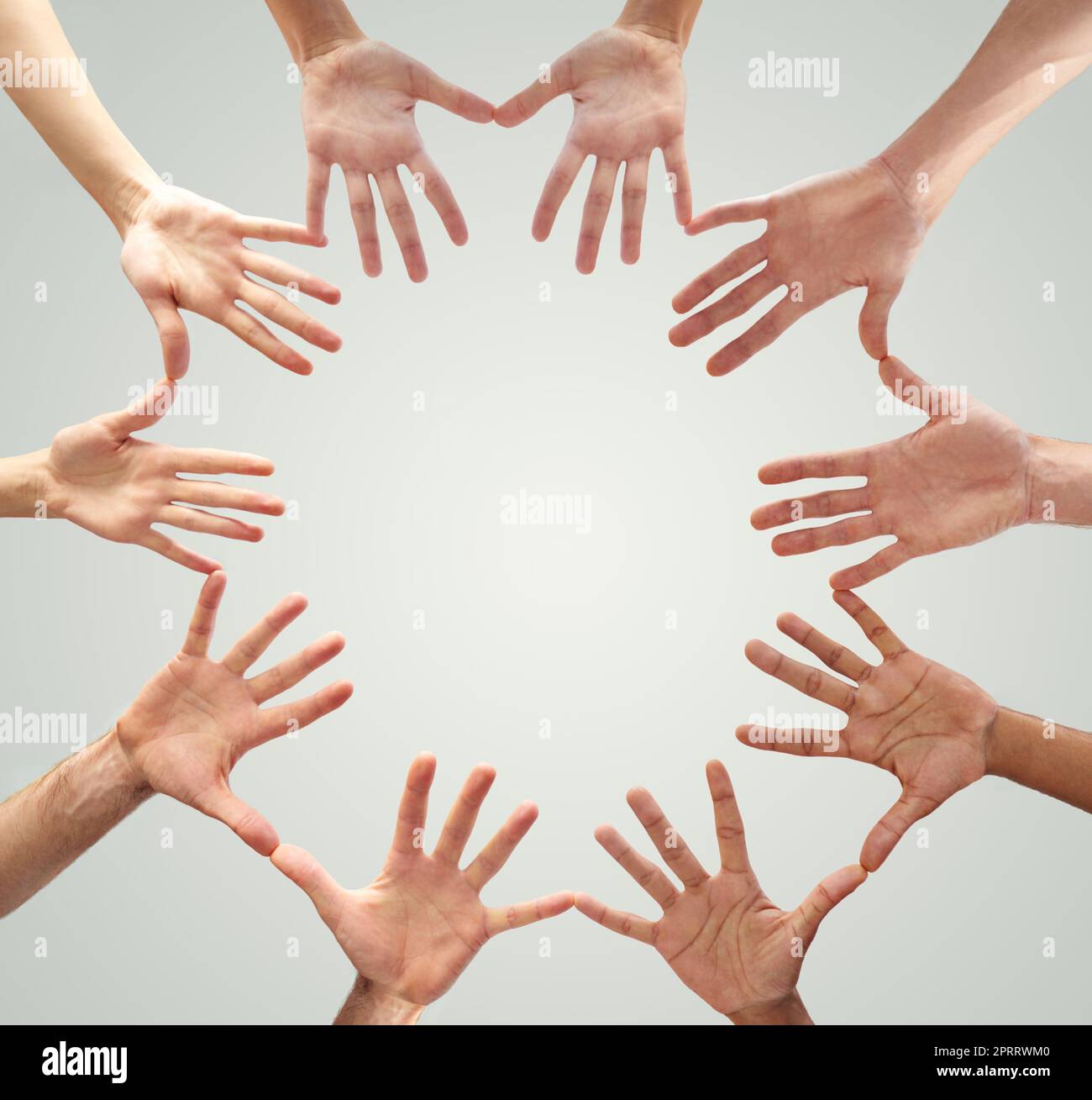 Many hands make light work. Low angle shot of hands in a circle forming a circle. Stock Photo