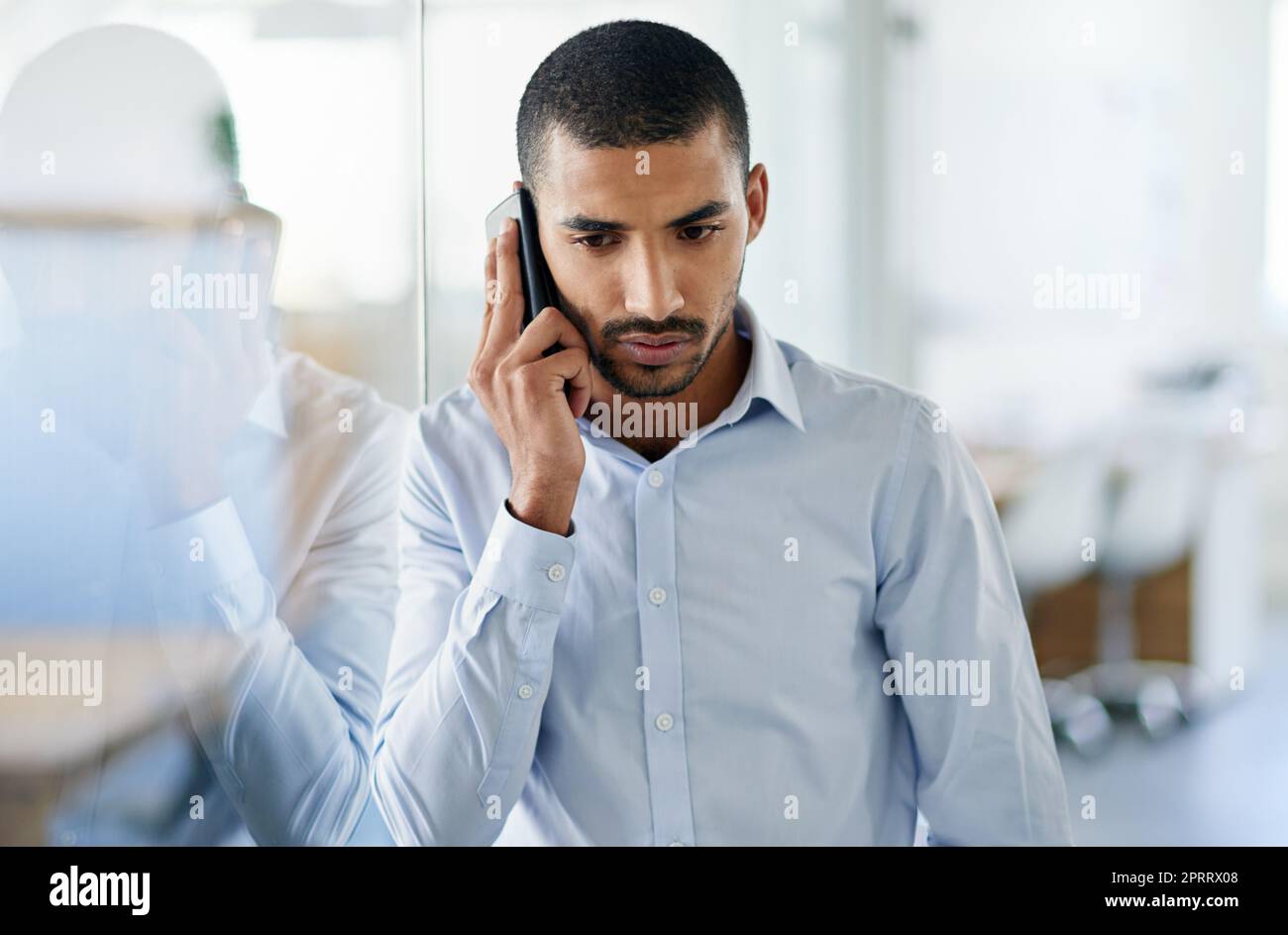 Hes got business on the line. a handsome young businessman talking on his cellphone in the office. Stock Photo