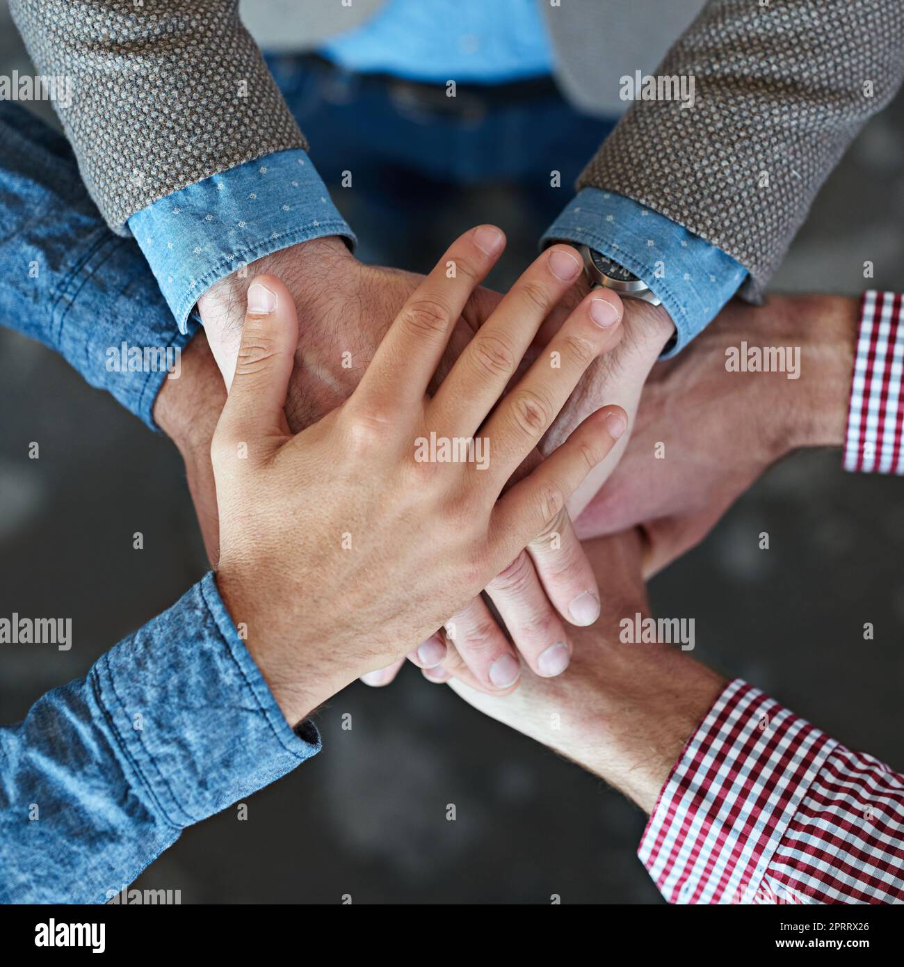 All for one. Top view of co-workers hand put together in an expression of unity and team spirit. Stock Photo