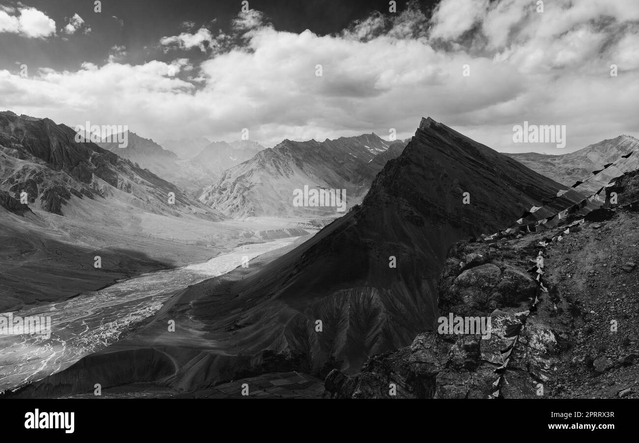 The Spiti river flanked by high peaks of the Himalayas under a blue, clouded sky near Kaza, Himachal Pradesh, India. Stock Photo