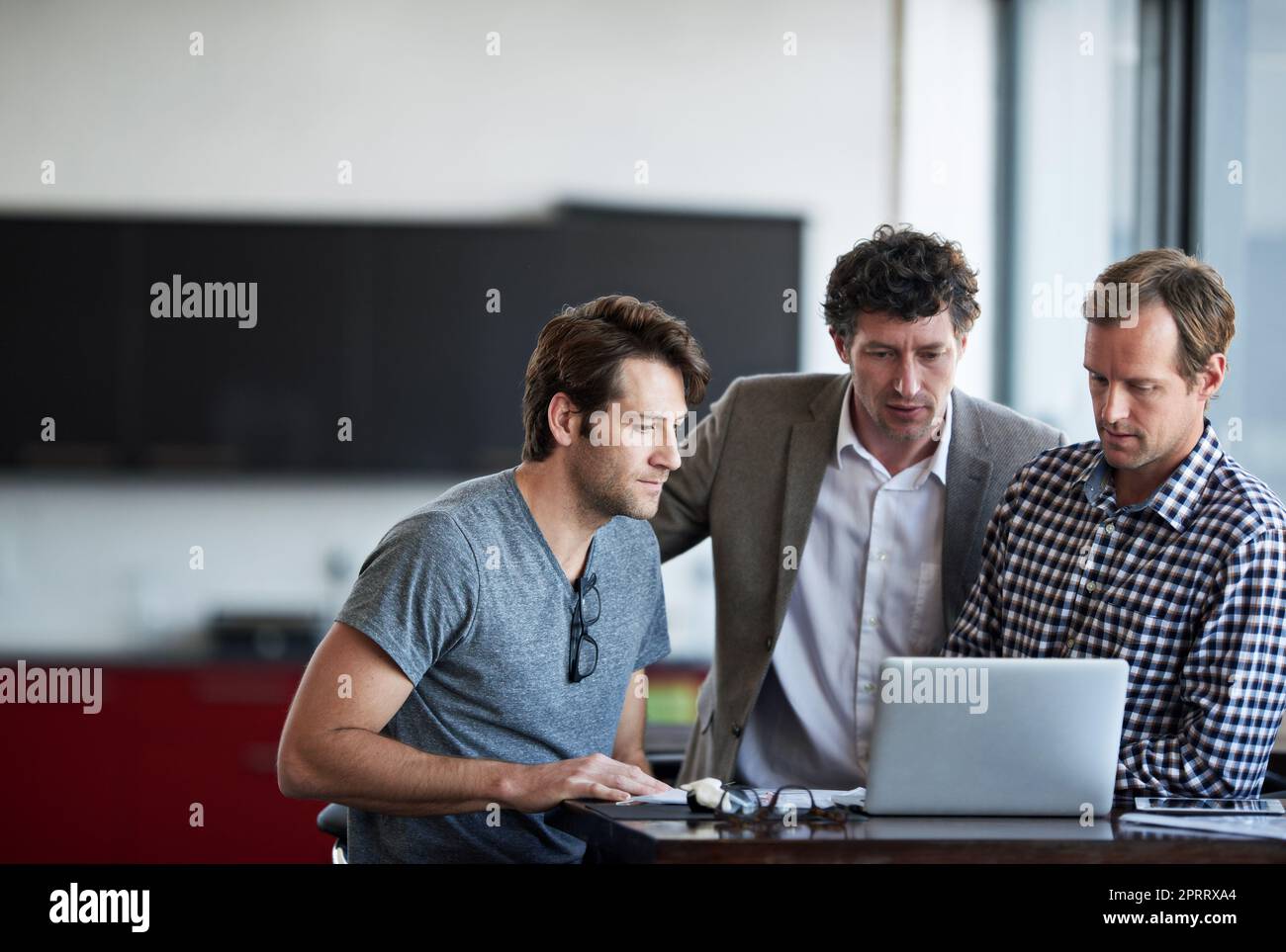 Its almost perfect. three businessman discussing work in the office. Stock Photo