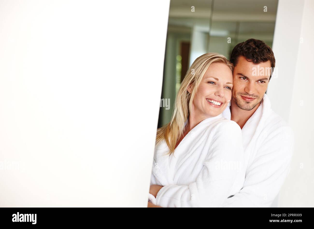 Ready for another day. A loving young couple in bathrobes relaxing at home. Stock Photo