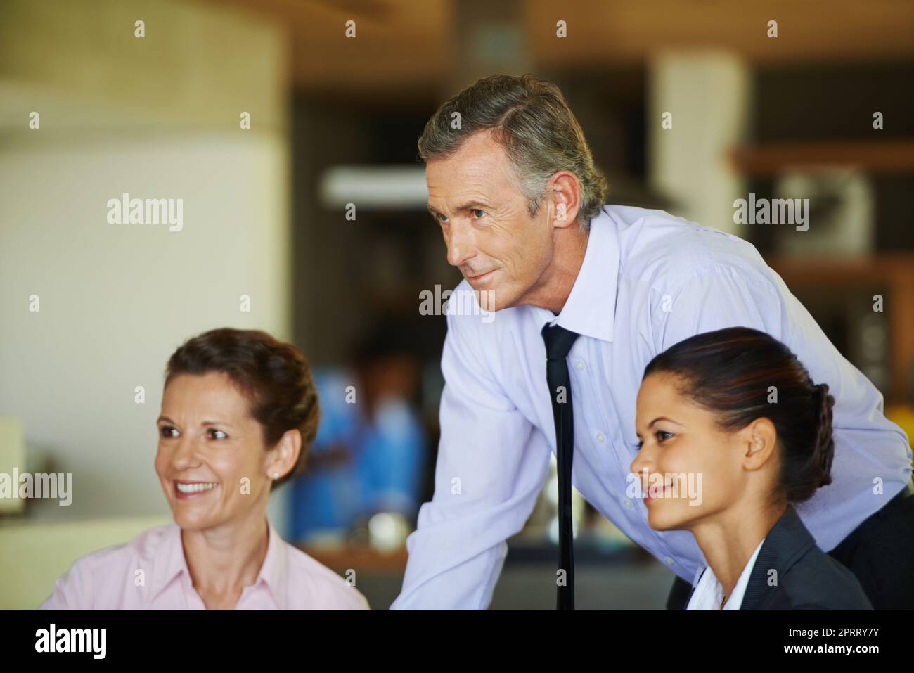 Gaining valuable corporate insight. Three coworkers together in a meeting. Stock Photo