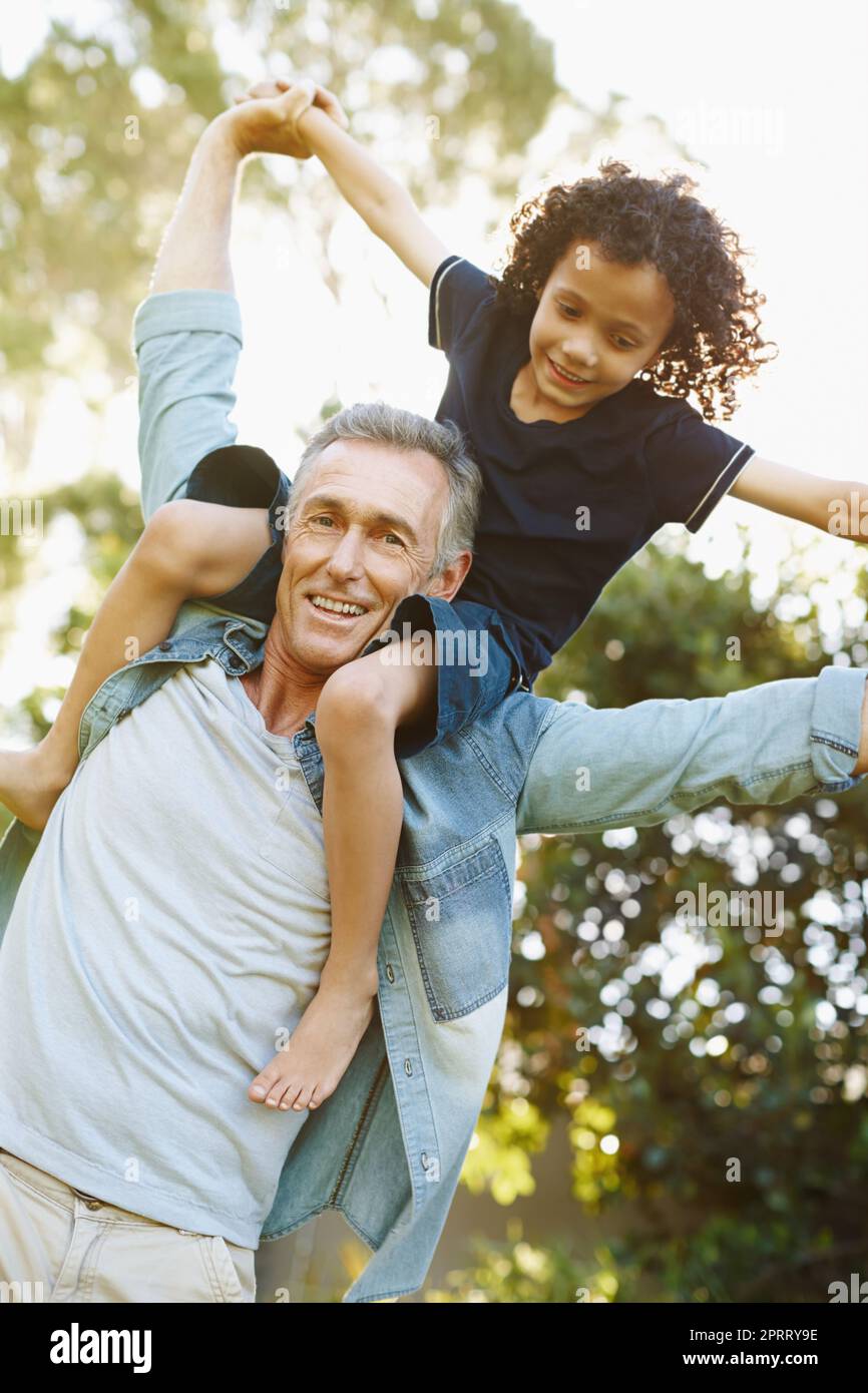 Hes such a joy to me. A grandfather playing with his grandson in the park. Stock Photo