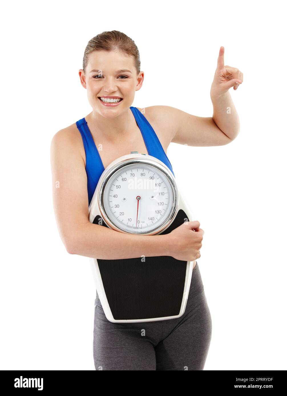 Pointing to her weight-loss secret. A pretty teenager carrying a scale and pointing up at copyspace. Stock Photo