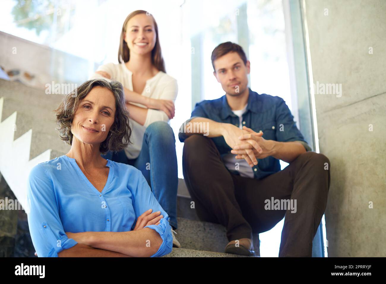 Proud of our little family. a mother standing in front of her adult children on the stairs. Stock Photo
