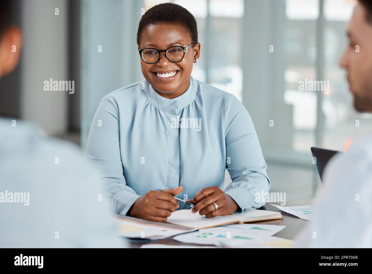 Planning meeting, business partnership and black woman with smile for marketing team strategy, work communication and happy with office collaboration. African manager talking to employees at company Stock Photo