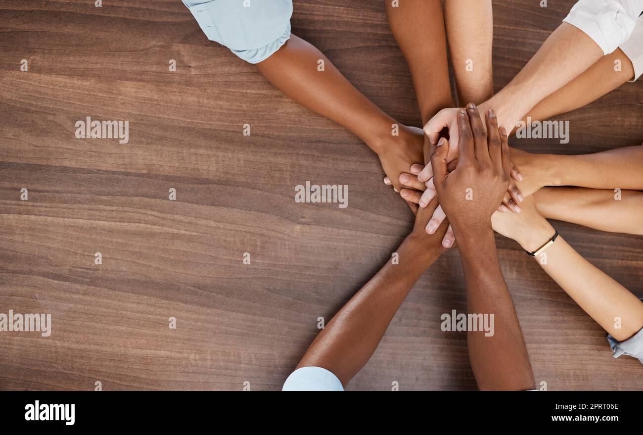 Diversity, teamwork and hands together at table in office with corporate company people mock up. Trust, support and respect in business with diverse people working on collaboration in workplace. Stock Photo