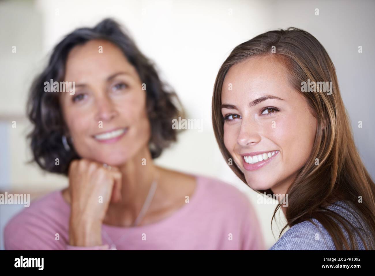 Her mom will always be her best friend. A mother and daughter smiling happily while they spend time indoors. Stock Photo