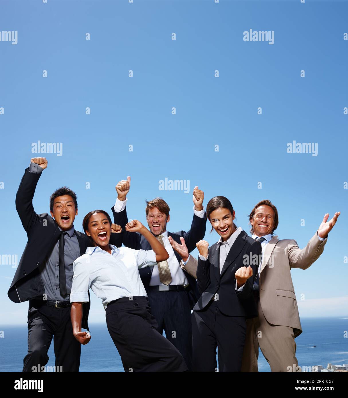 The skys the limit. a group of business people acting excited with their hands in the air. Stock Photo