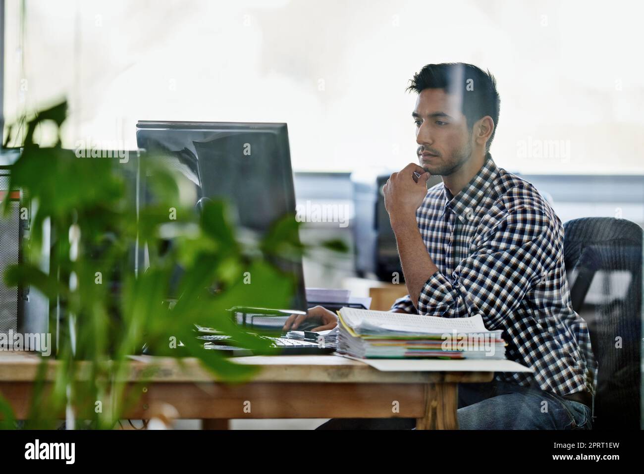 Coming up with a fool-proof plan. a handsome young designer working on a pc. Stock Photo